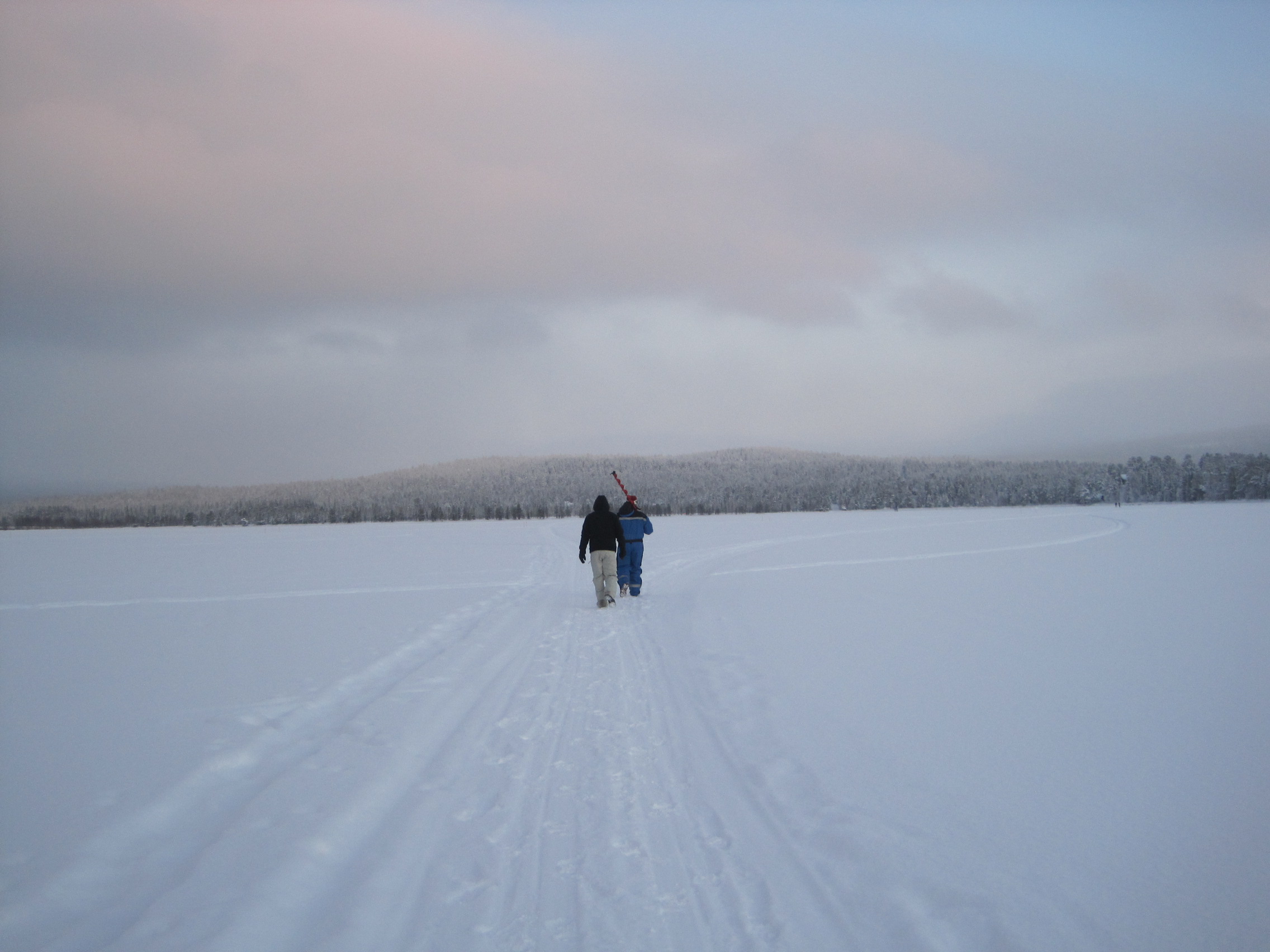 Walking across a frozen lake in Lapland, Finland at dusk